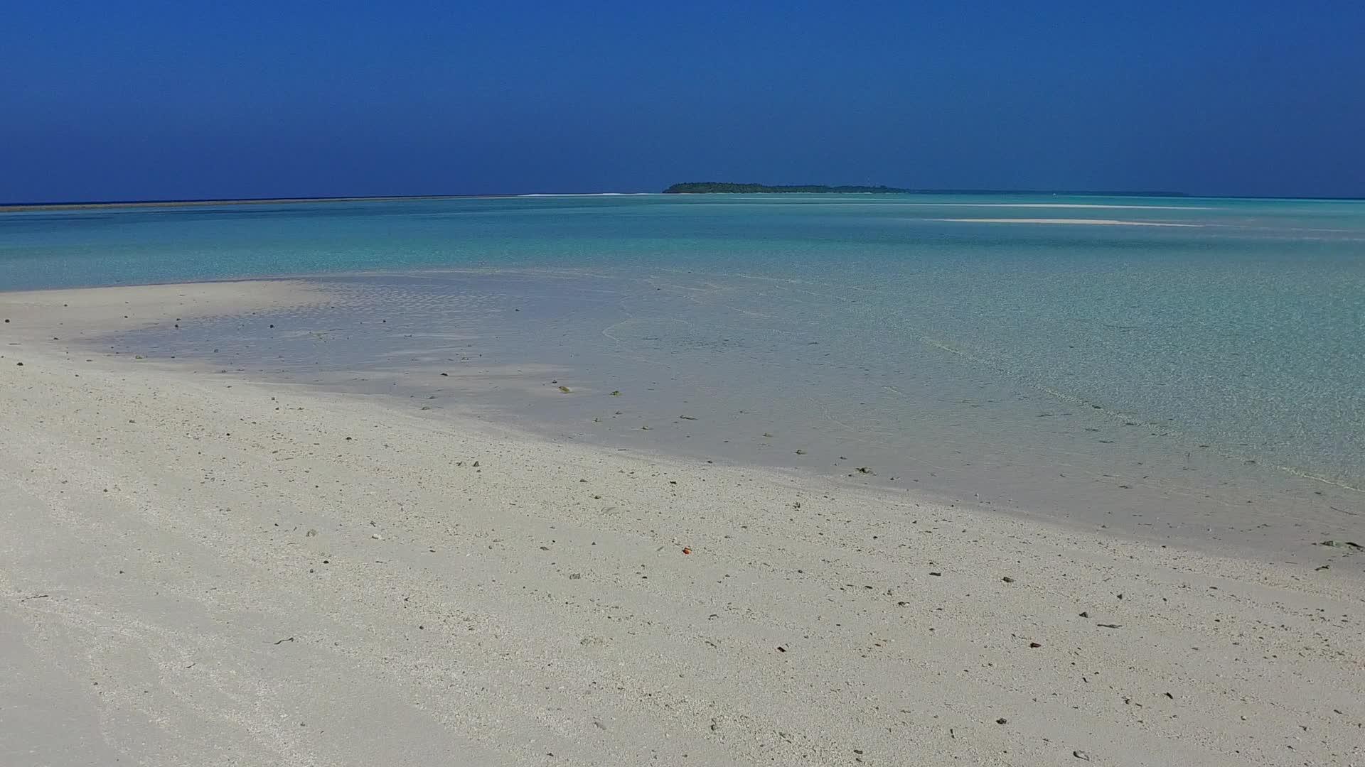 海滩上以明亮的水和日落前的白色沙子为背景视频的预览图