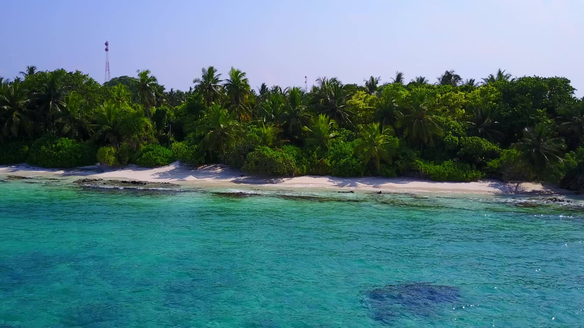 在绿色海洋附近的度假胜地附近阳光明媚的海滨海滩风景视频的预览图