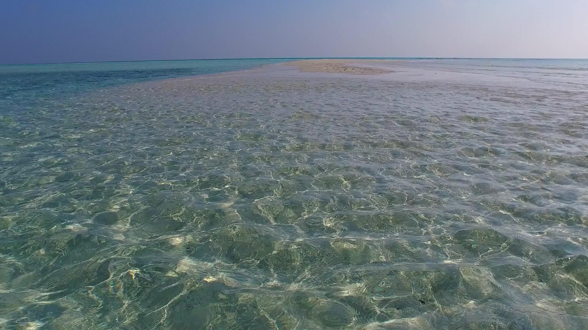 阳光明媚的豪华海岸海滩风景沿着蓝海和沙巴岛附近的白色海滩背景视频的预览图