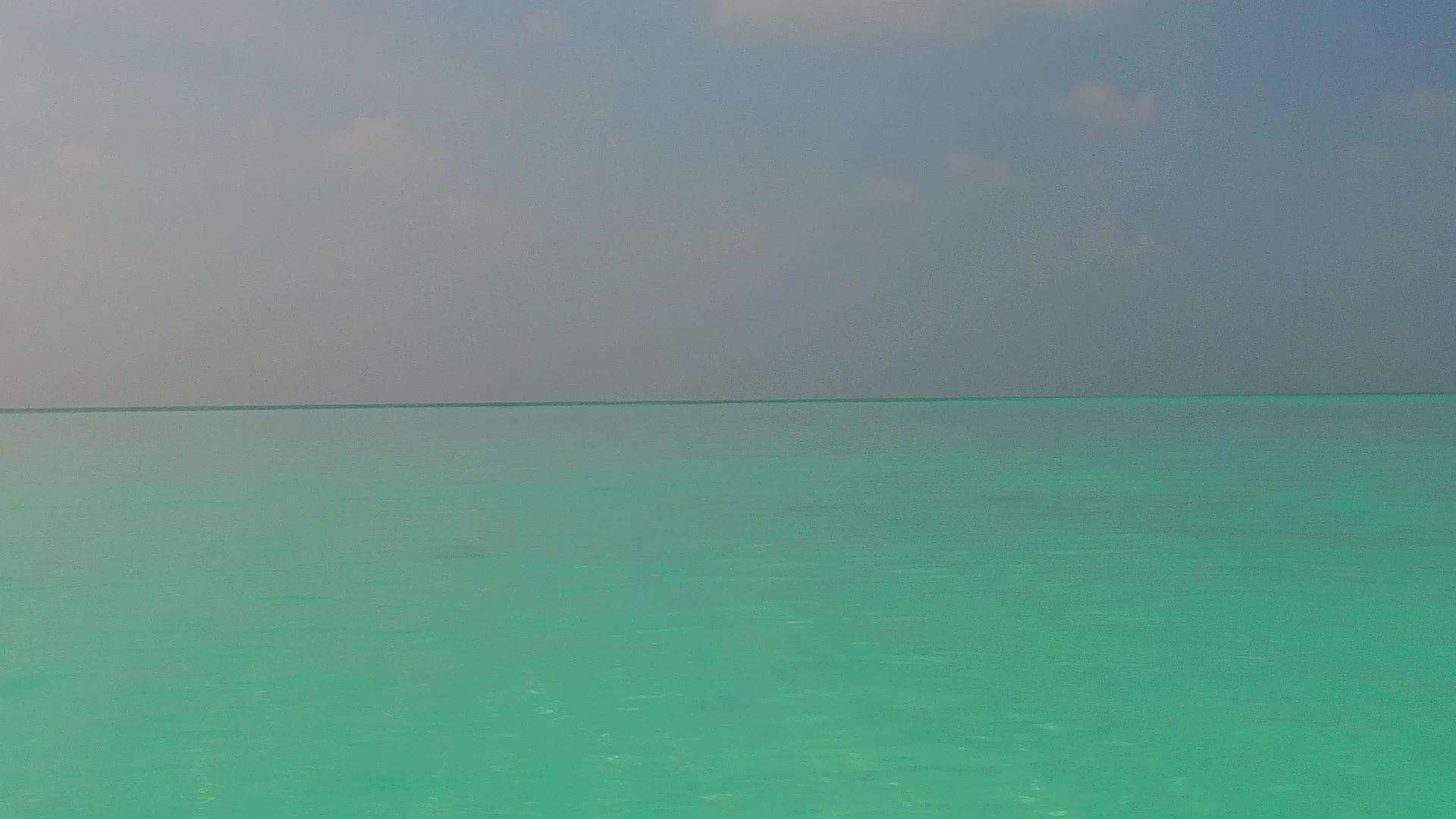 沿着蓝色航行海浪附近有一个白色的沙底背景视频的预览图