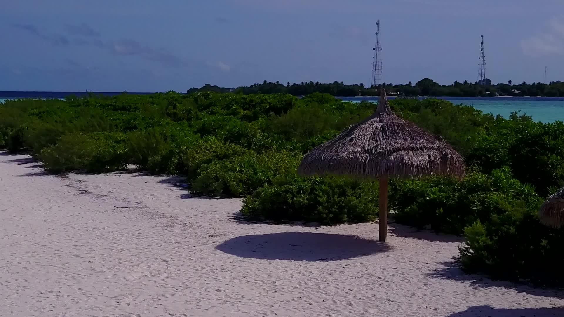 通过蓝绿环礁湖和海浪附近的浅沙背景关闭豪华海湾视频的预览图