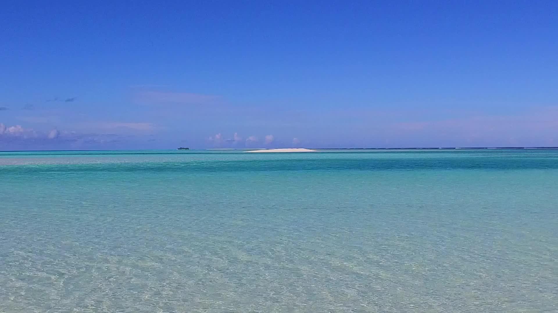 白沙背景的蓝色海洋沿着蓝色海滩沿着蓝色海滩航行视频的预览图