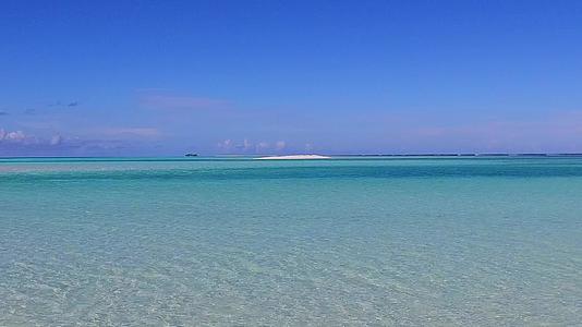 白沙背景的蓝色海洋沿着蓝色海滩沿着蓝色海滩航行视频的预览图