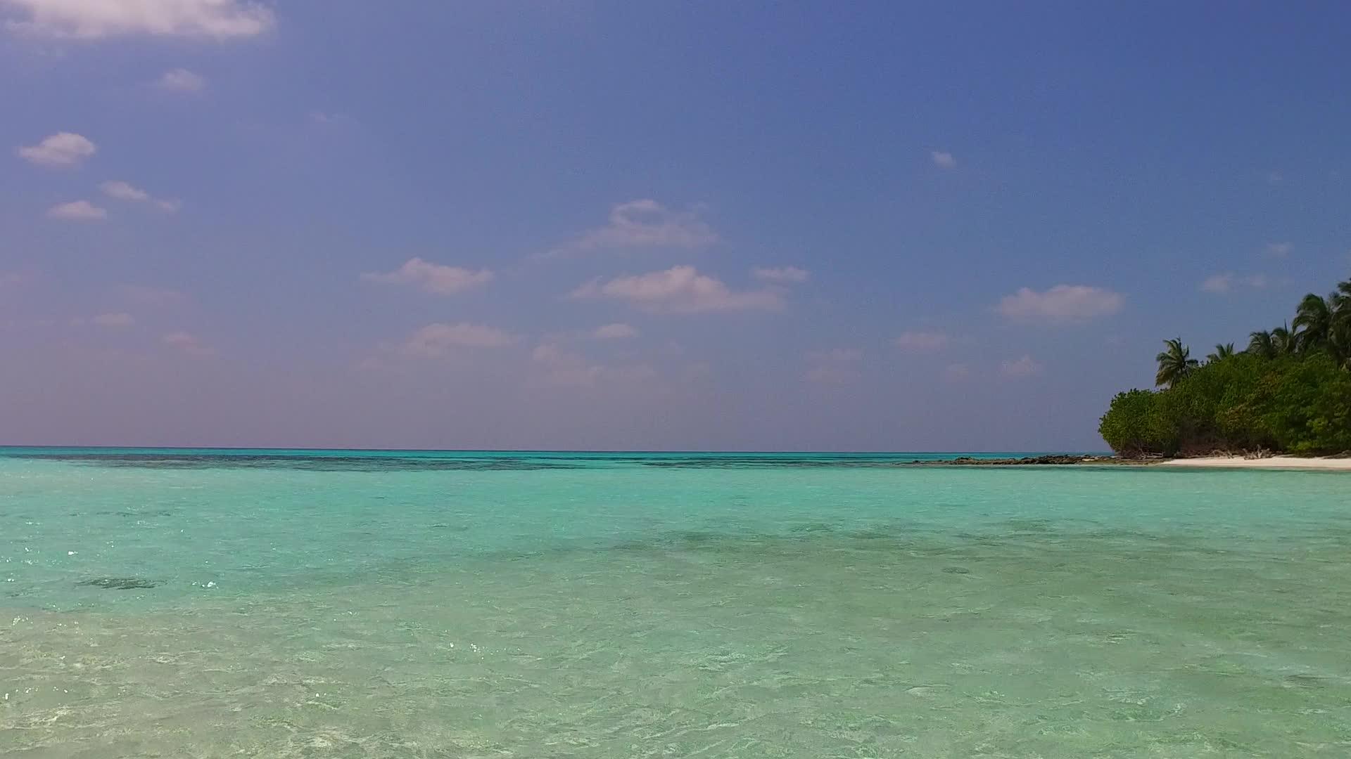 日落前蓝色环礁湖和白色沙滩背景下阳光明媚的热带度假胜地视频的预览图