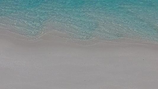 在明亮的水和白色的海滩背景下海浪附近的阳光晴朗视频的预览图