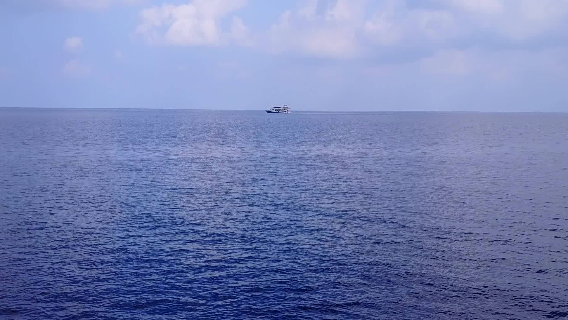 沿着透明的海洋在沙巴附近的白色沙滩背景下航行视频的预览图