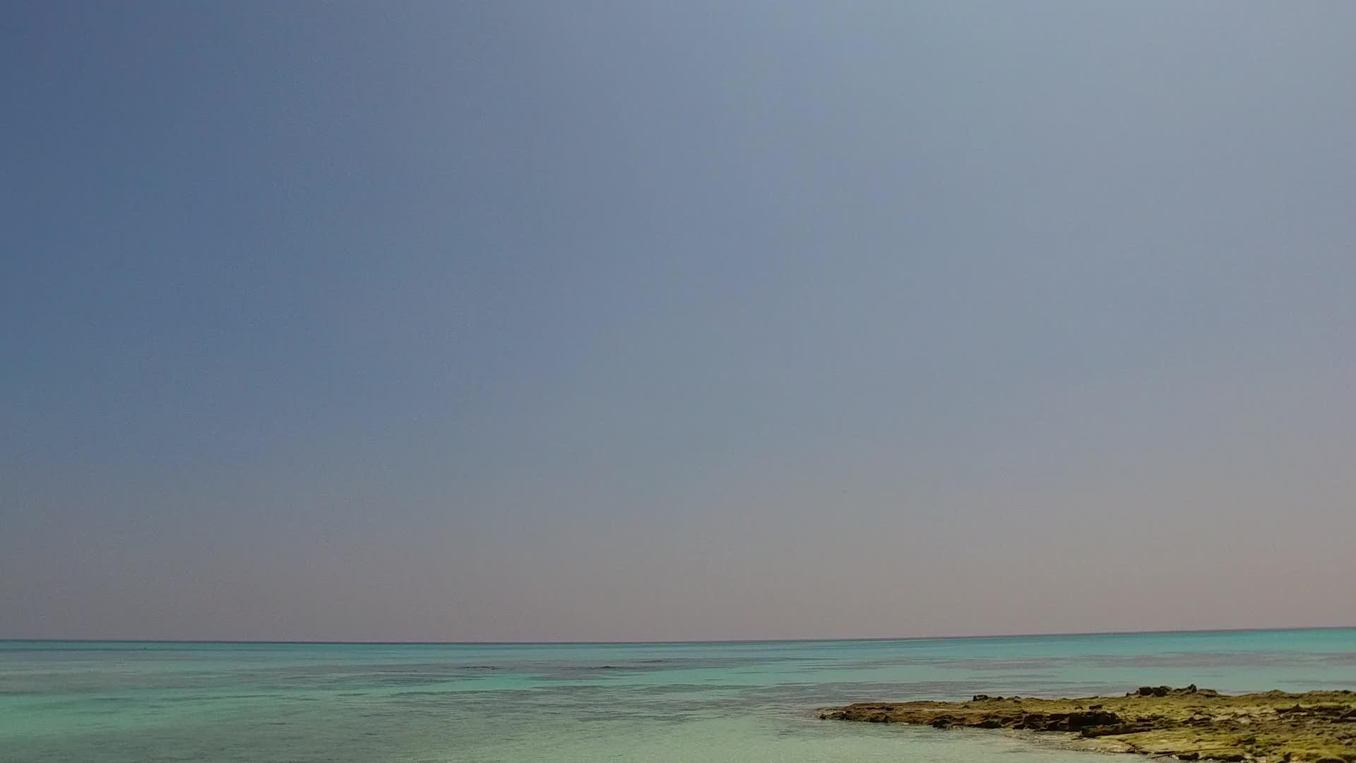 以蓝光下浅沙背景的蓝色水礁湖为例平静的旅游海滩是空的视频的预览图