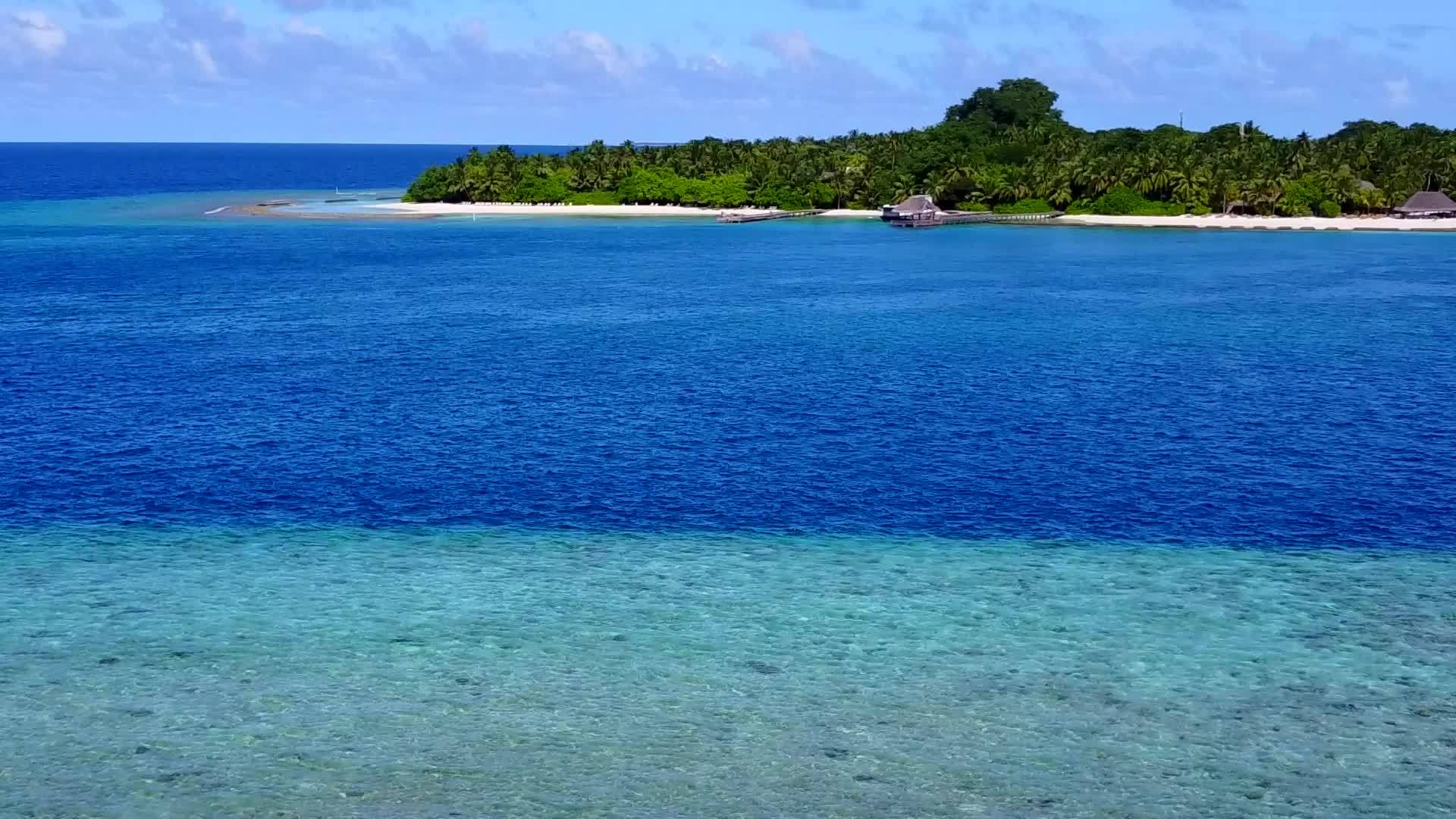 浅海和白色沙地的背景环绕着浅海和棕榈树附近的白色沙地视频的预览图