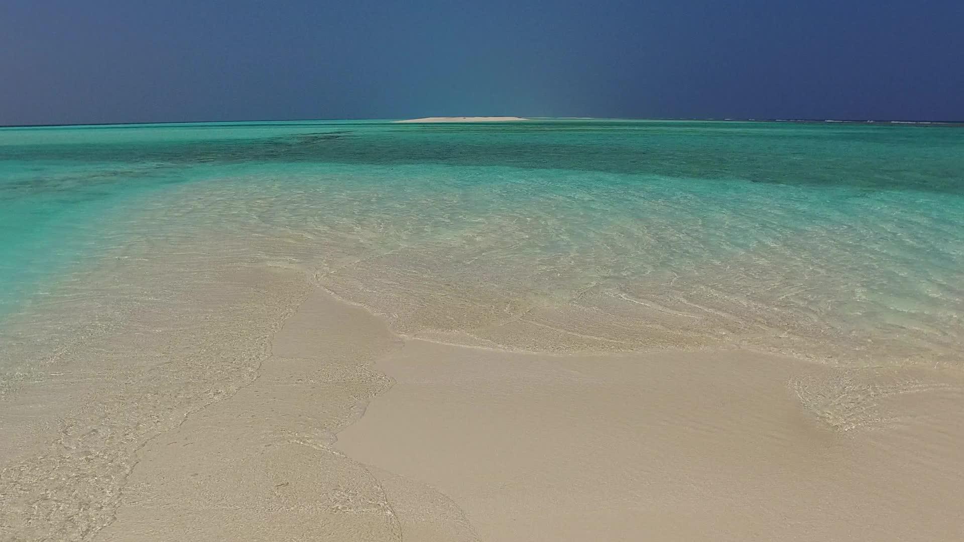 沿着沿海海滩航行的清空海景由蓝色海洋和冲浪附近的浅浅海洋组成视频的预览图