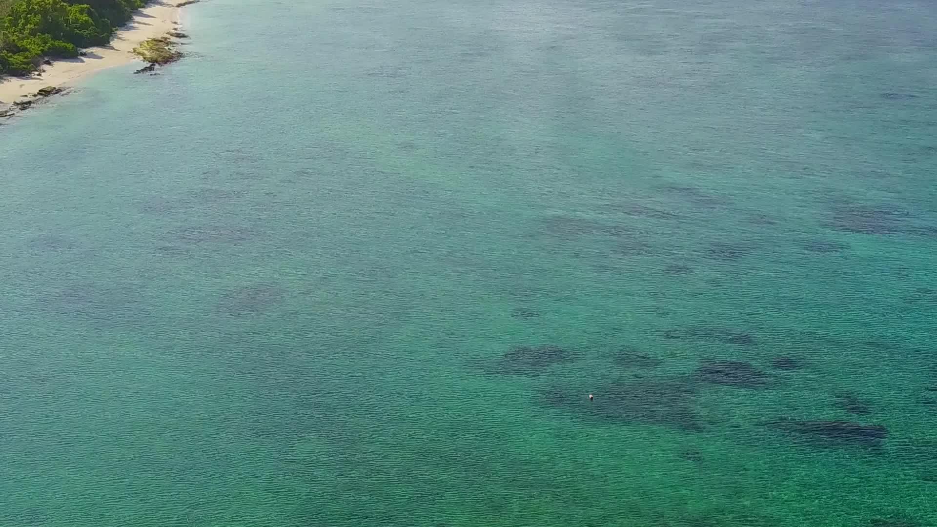 近距离欣赏蓝绿色海洋和暗礁附近的白色沙滩背景视频的预览图