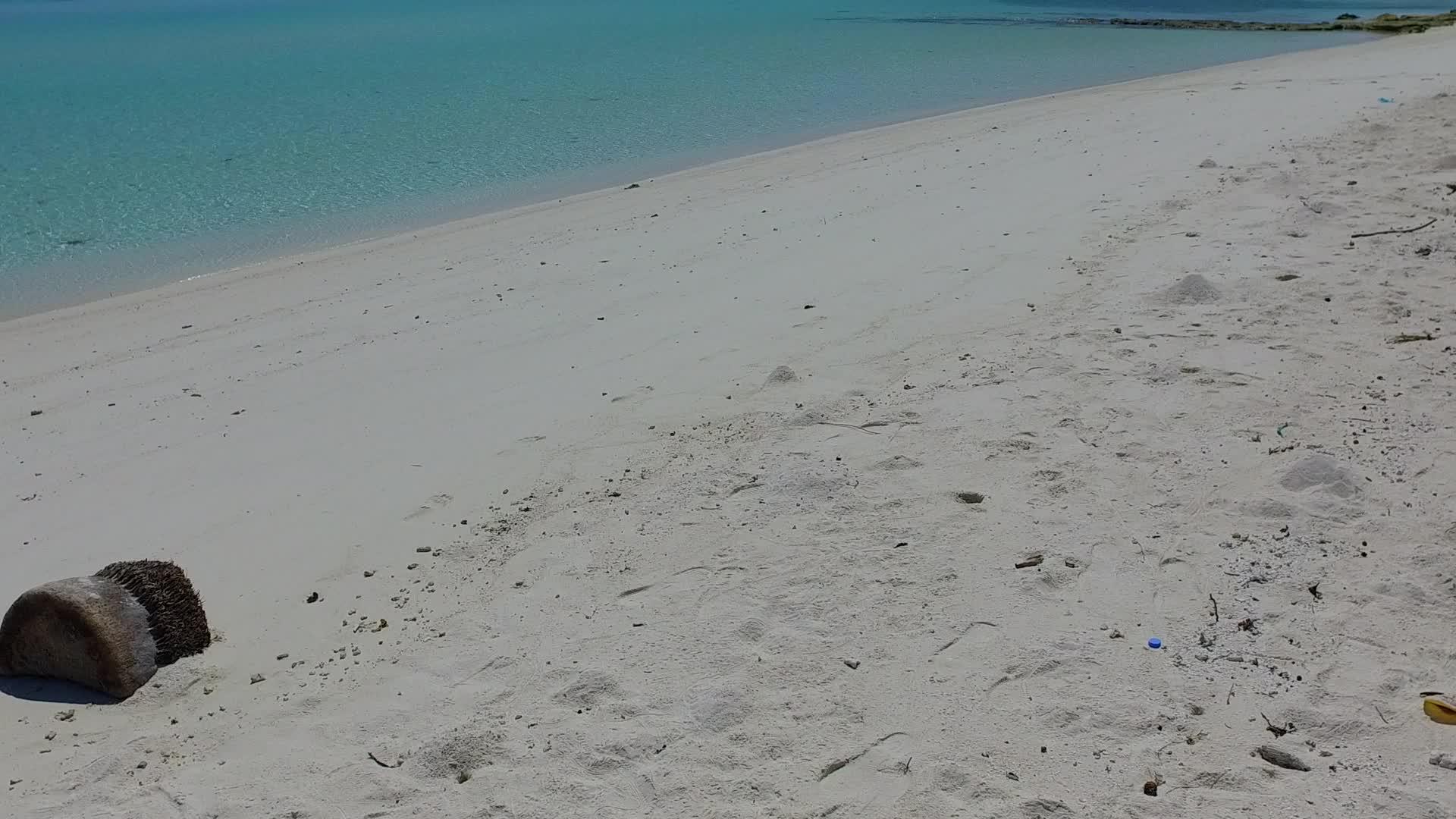 阳光明媚的海滩阳光明媚的天空蓝色的环礁湖和阳光下的白沙视频的预览图