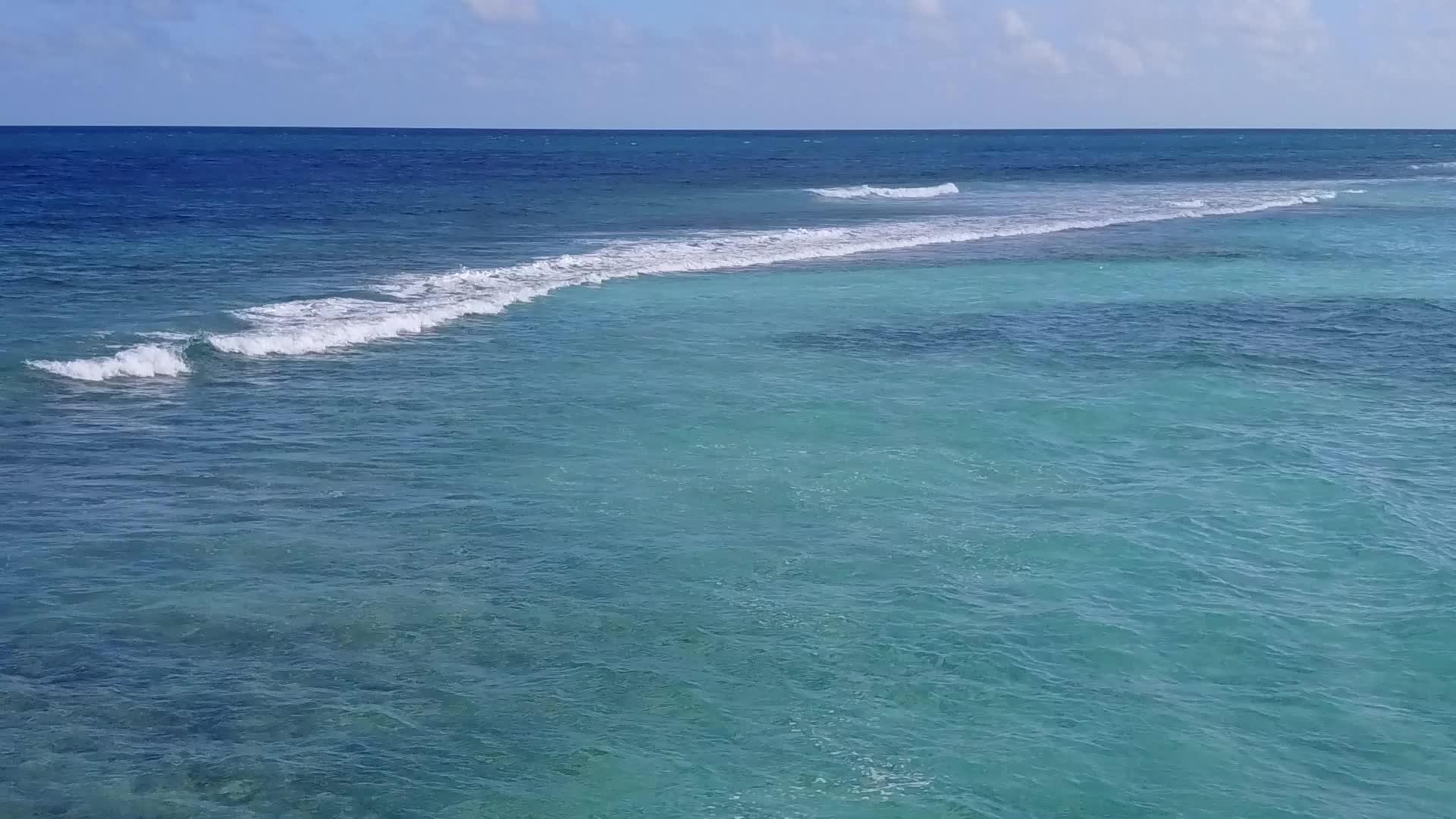 蓝色的海航行在蓝色的海面上棕榈树附近有浅沙的背景视频的预览图