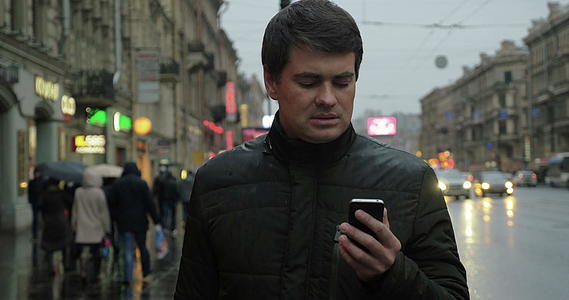 男人在街上使用智能手机视频的预览图