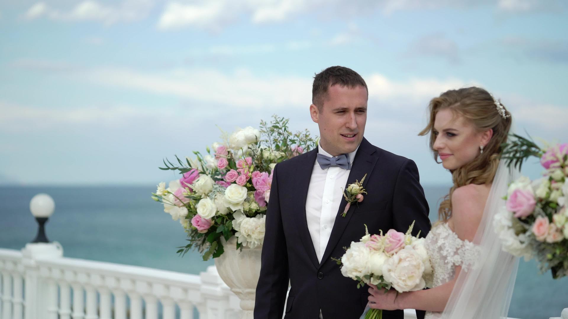 婚礼上一对相爱的年轻夫妇站在拱门旁边视频的预览图
