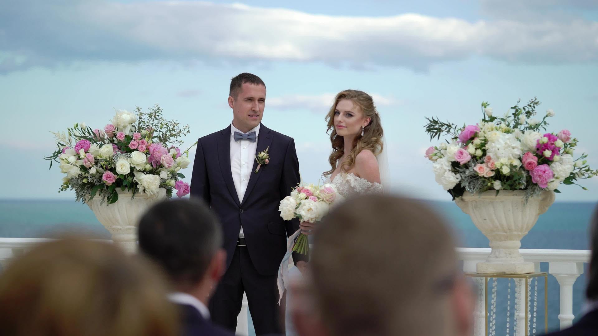 婚礼上一对相爱的年轻夫妇站在拱门旁边视频的预览图