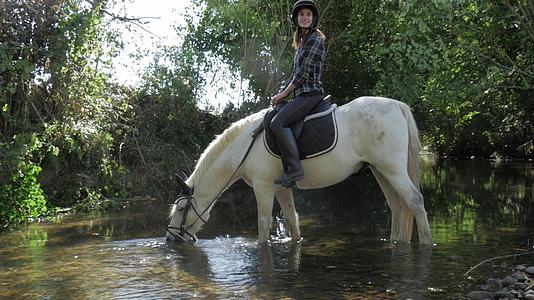 河水饮用水年轻女青年骑马视频的预览图