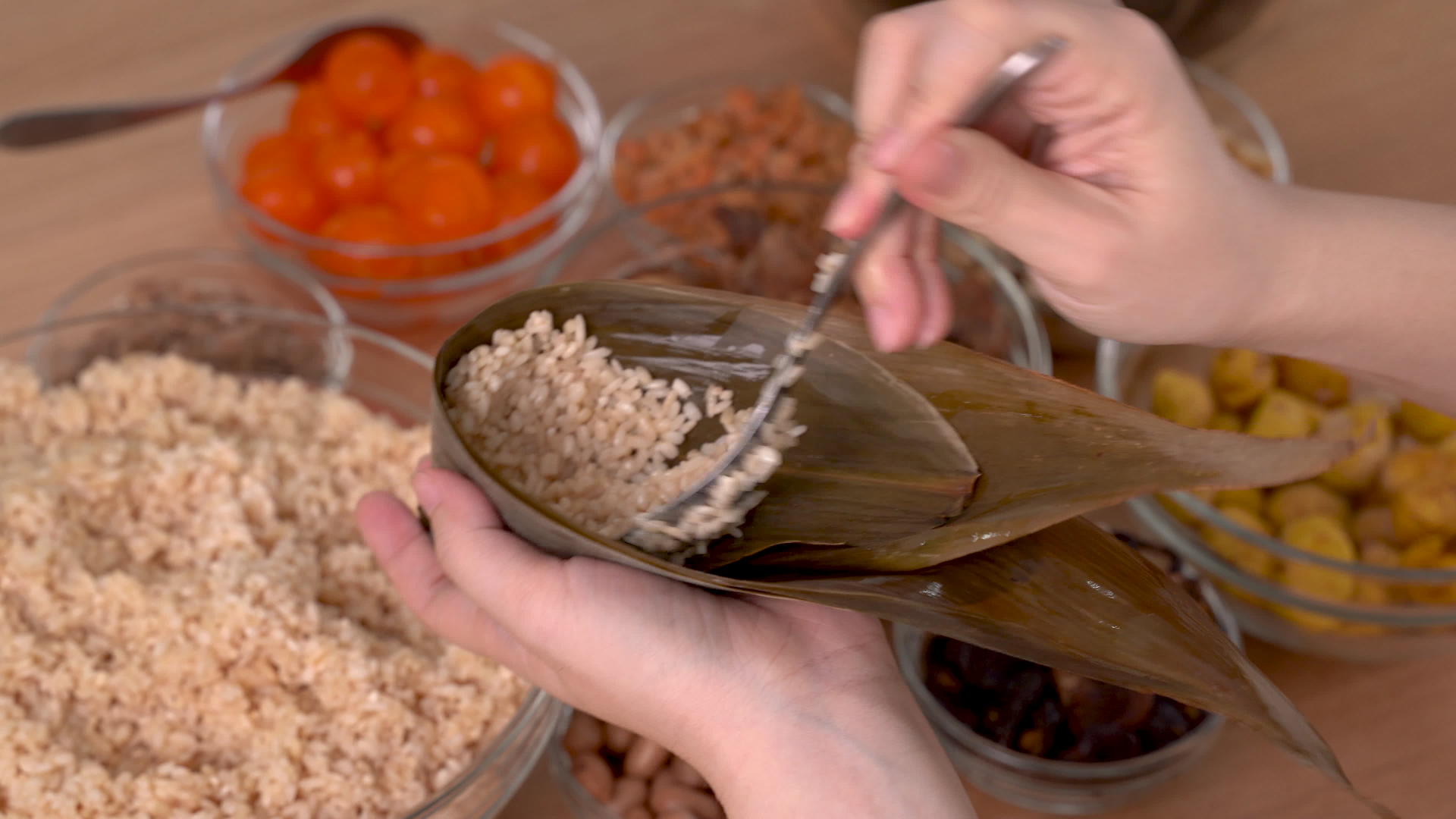 做粽子——一家人准备在家里的木桌上包一堆中餐视频的预览图