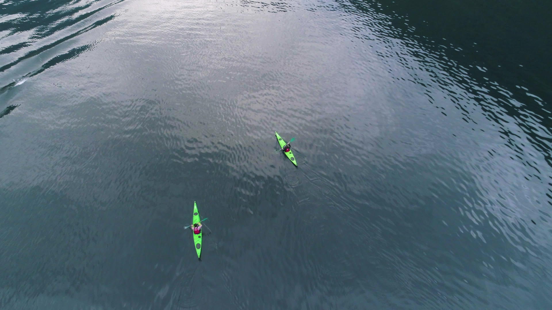 两艘绿色皮划艇在盖朗厄尔峡湾绿松石水中的无人机鸟瞰图视频的预览图