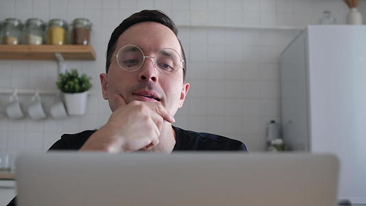 一位体贴、严肃的欧洲年轻学生作家坐在厨房里视频的预览图