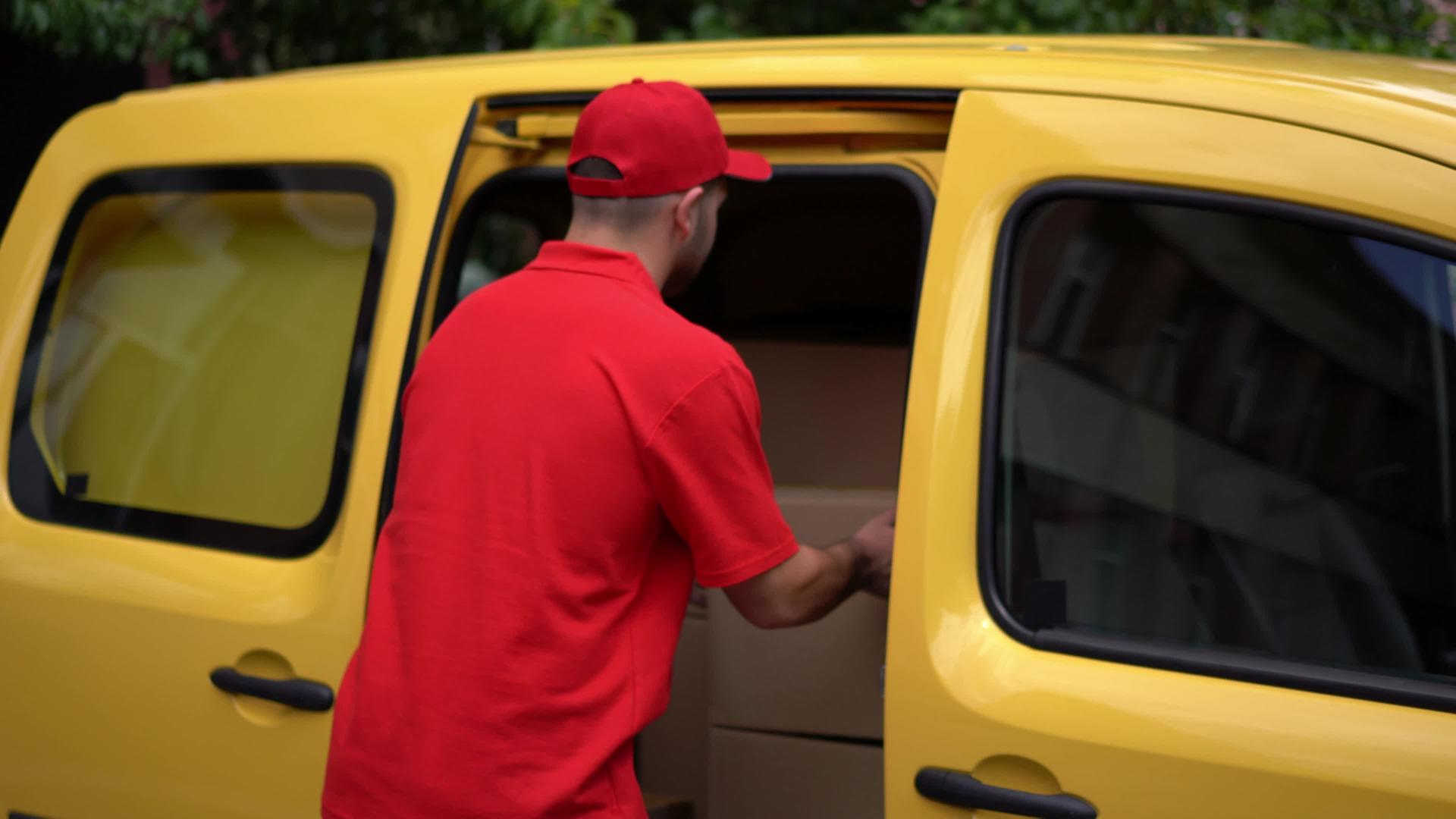 送货员从黄色汽车中取出包裹视频的预览图