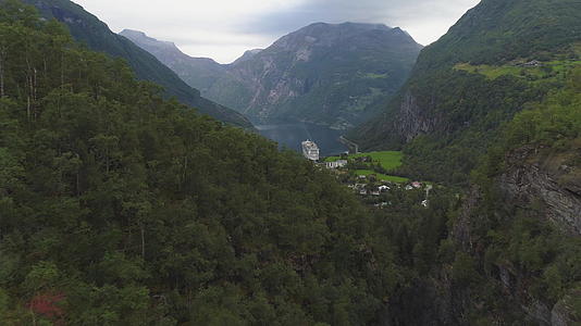 向前和向上飞过绿色的山丘显示北北有游轮Geirangerfjord视频的预览图