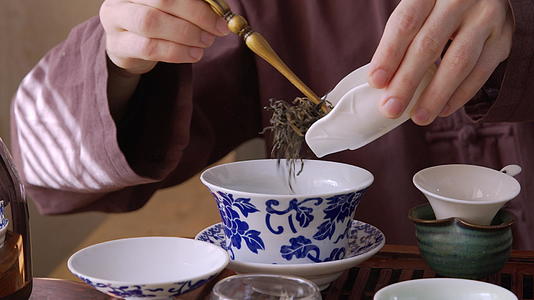 在茶碗里倒茶叶的手视频的预览图