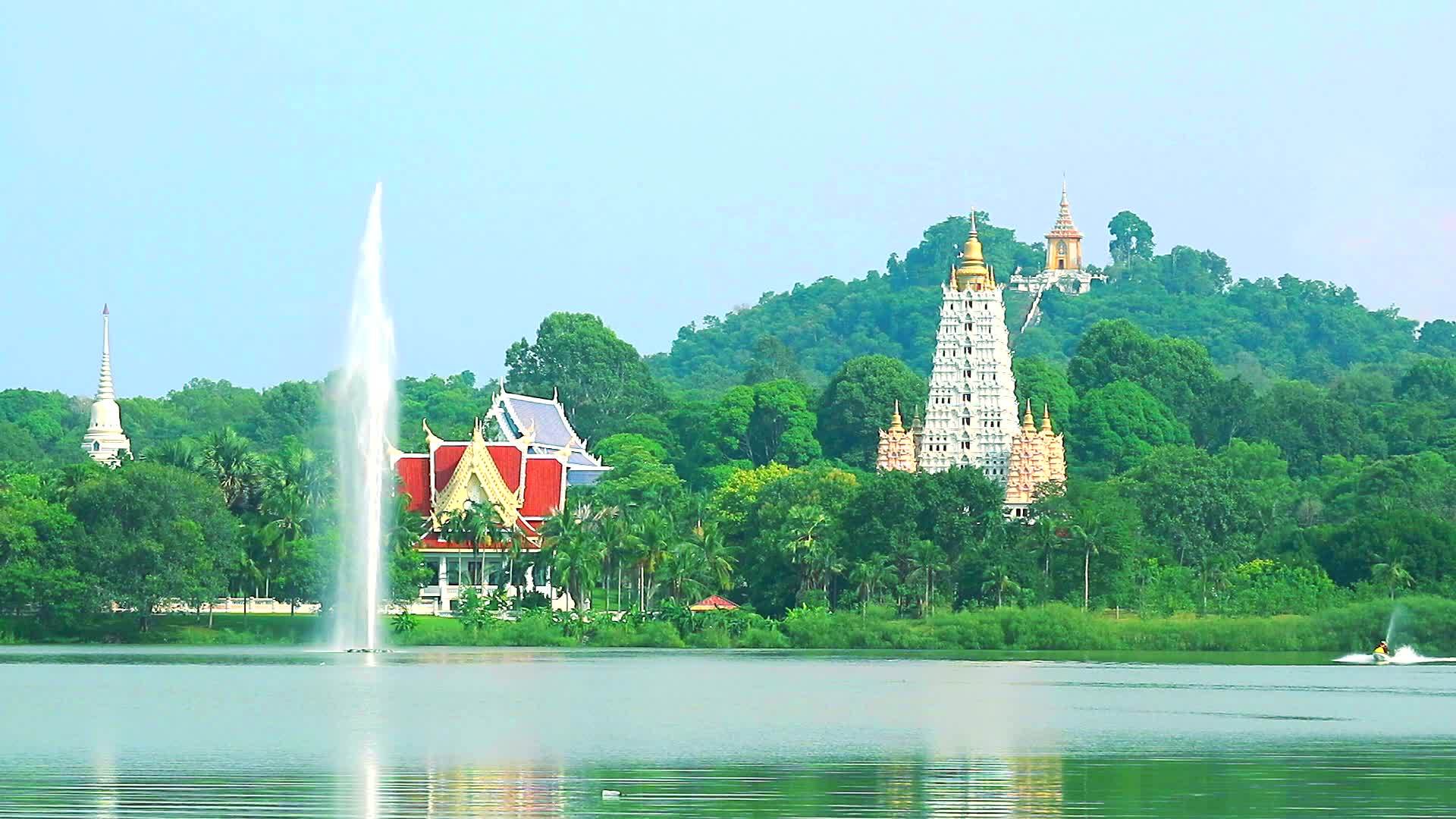 湖边的喷泉山上有茂密的寺庙视频的预览图