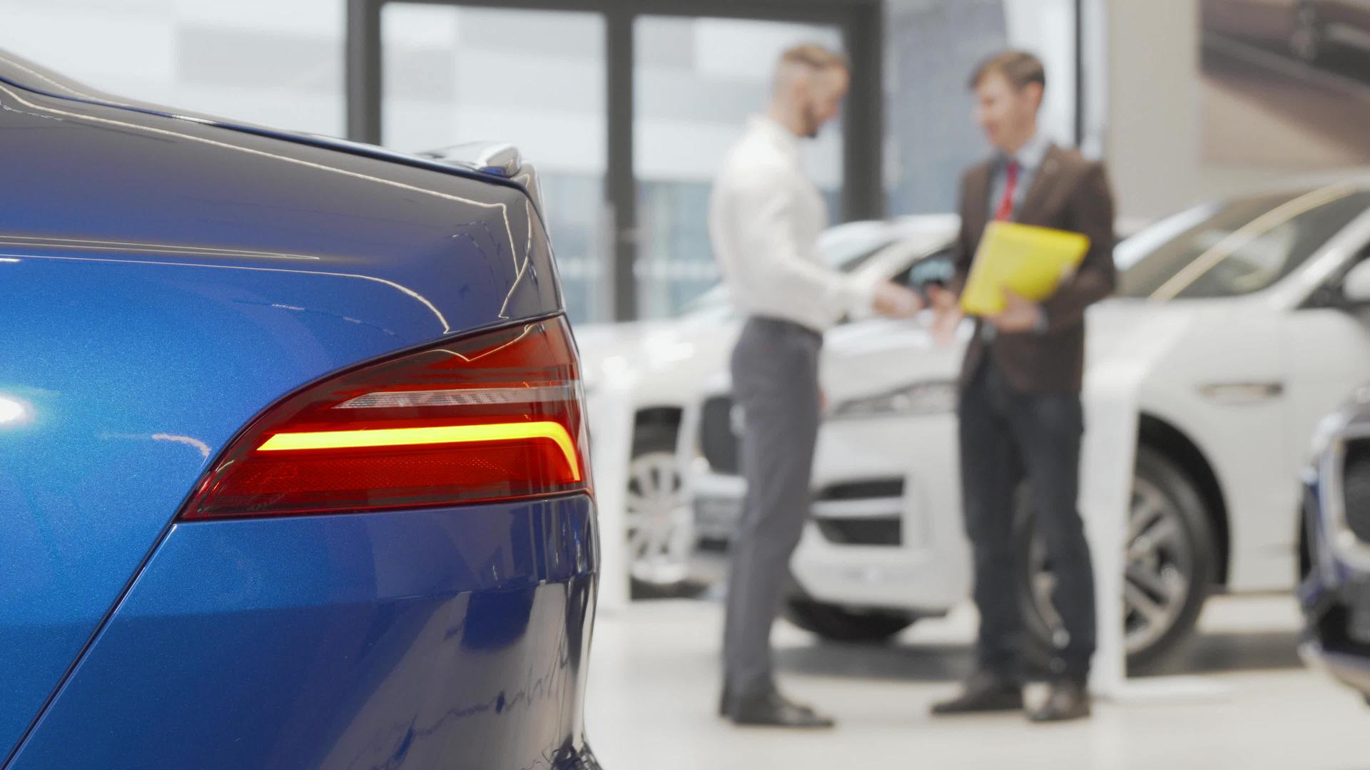 汽车经销商与汽车经销商的男性客户握手视频的预览图