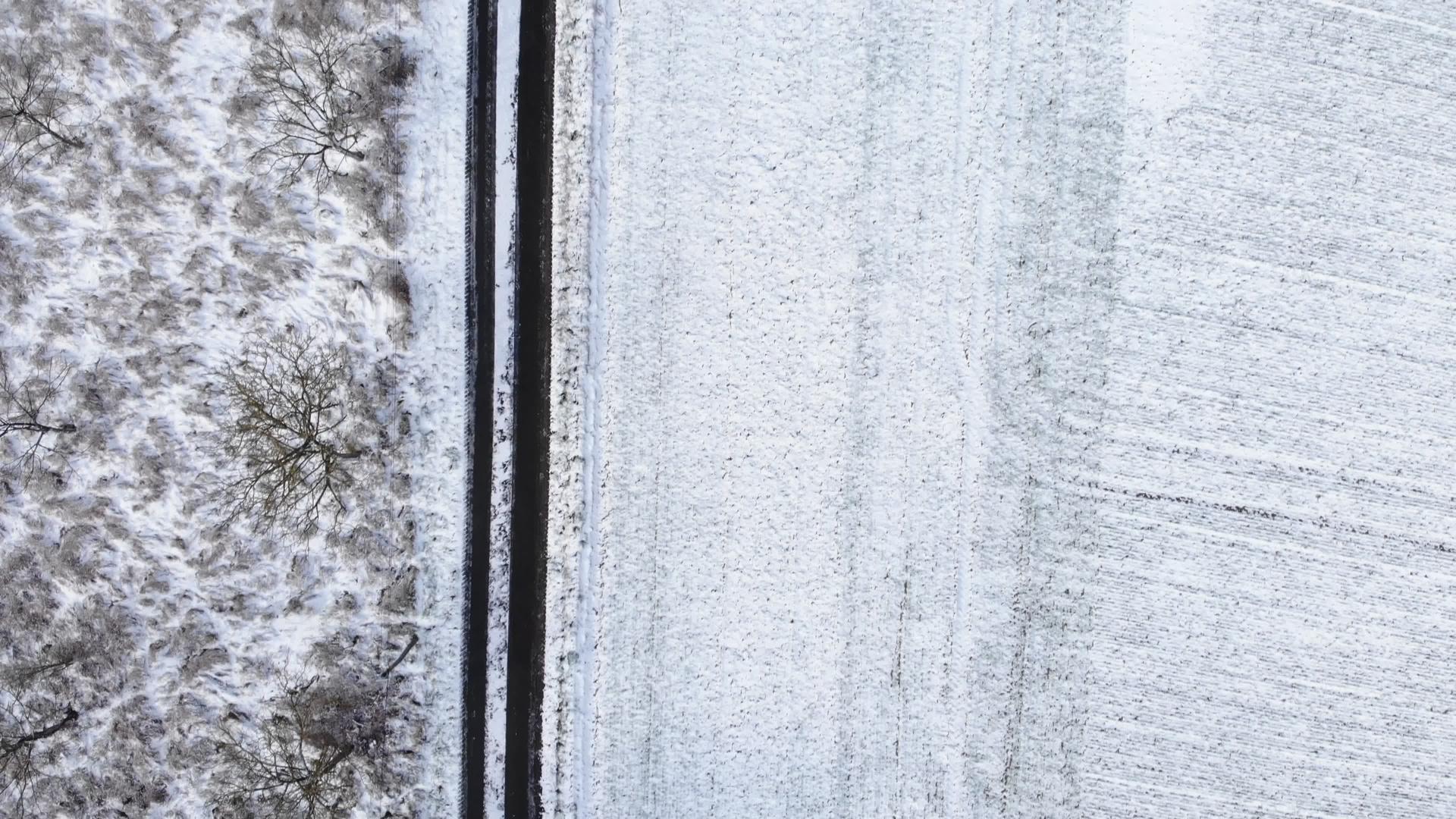 乡间小路穿过美丽的雪覆盖风景鸟瞰图无人机摄影美丽的美丽视频的预览图
