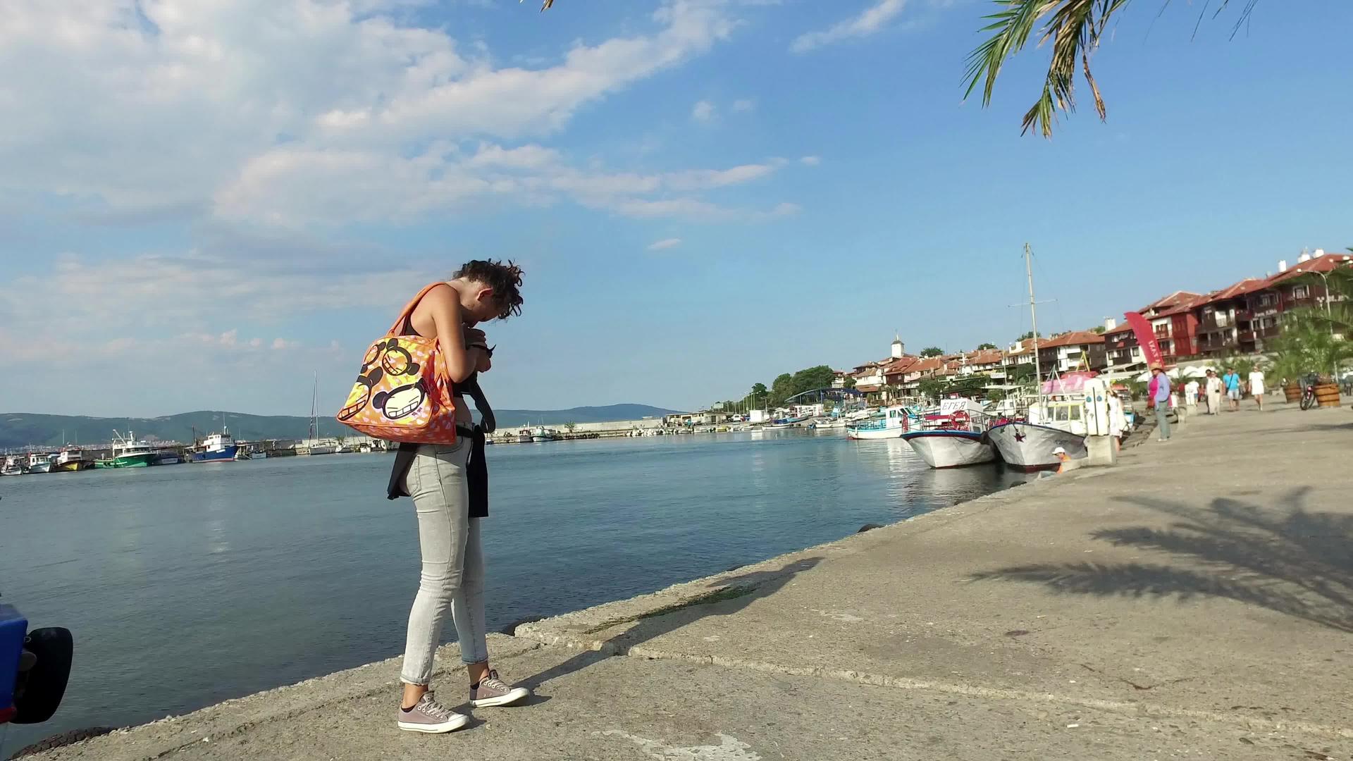 女摄影师在Bulgaria在内斯巴海滨码头附近拍照视频的预览图