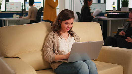 女经理坐在舒适的沙发休息区找笔记本电脑视频的预览图