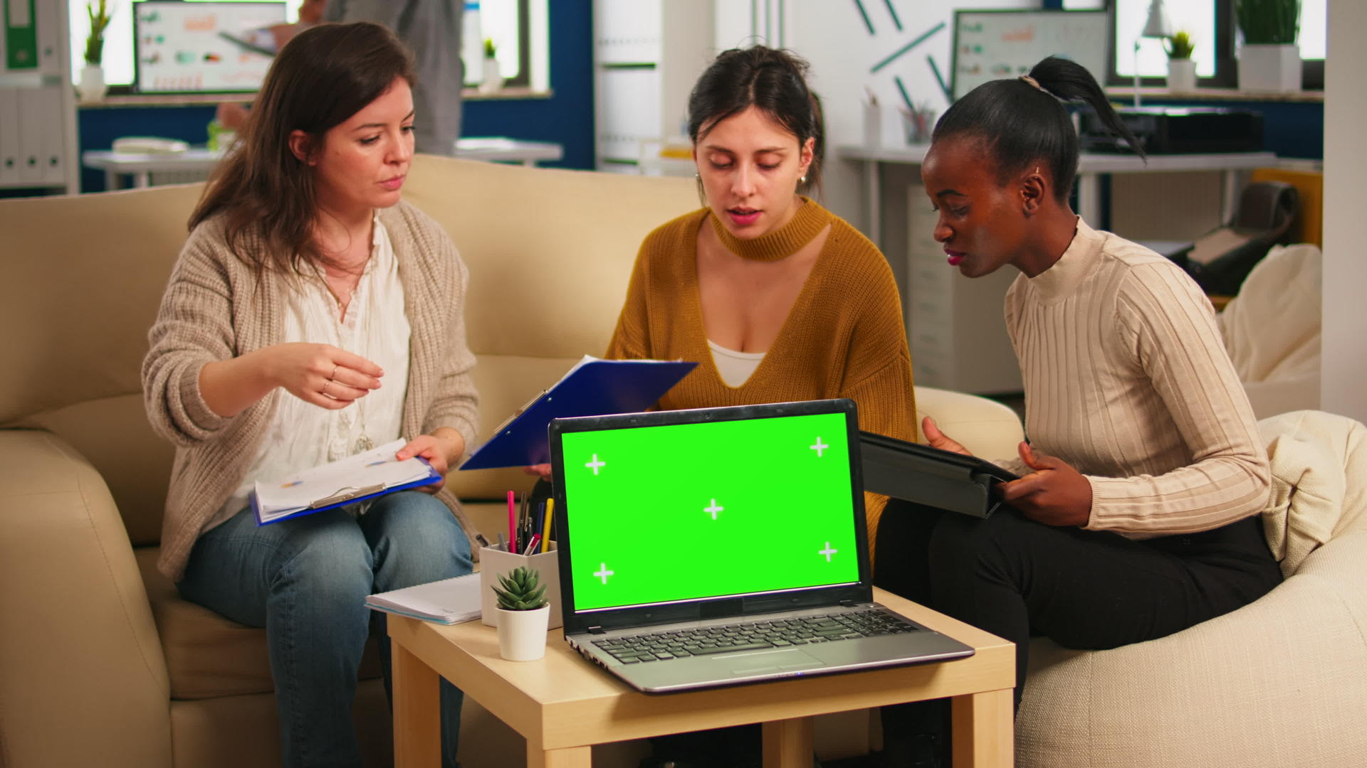 坐在桌子旁与绿色屏幕笔记本电脑讨论策略的多样性视频的预览图