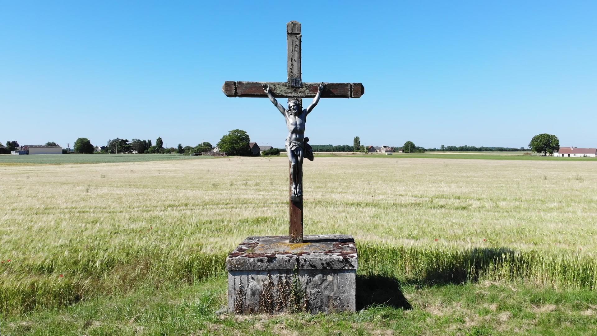 十字架上的耶稣基督雕像被钉在十字架上沿着法国农村的道路视频的预览图