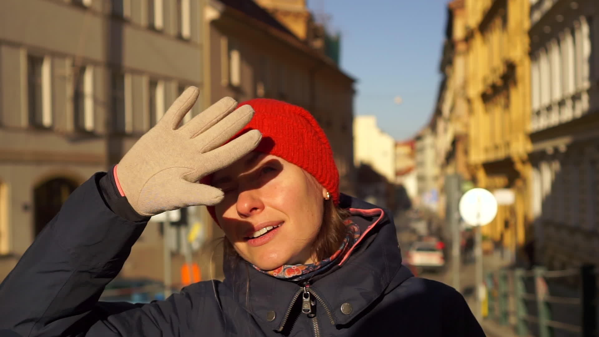 从欧洲老街阳光明媚的冬天开始戴着红帽子的年轻女性视频的预览图