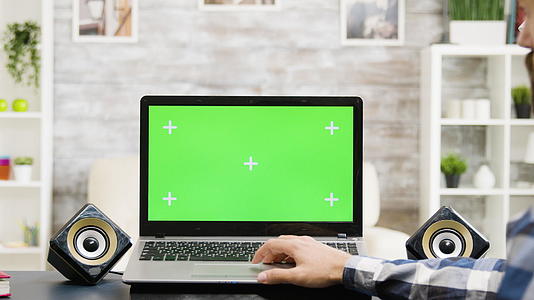 现代公寓的绿色屏幕上有一台绿色的笔记本电脑视频的预览图