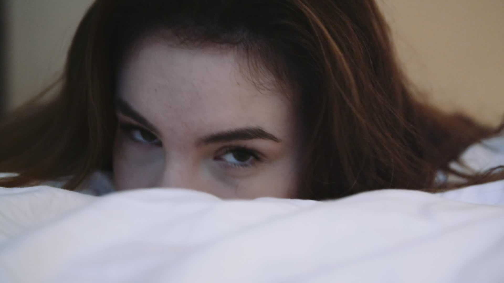 年轻女性的眼睛看着躺在床上摇摇头的相机视频的预览图