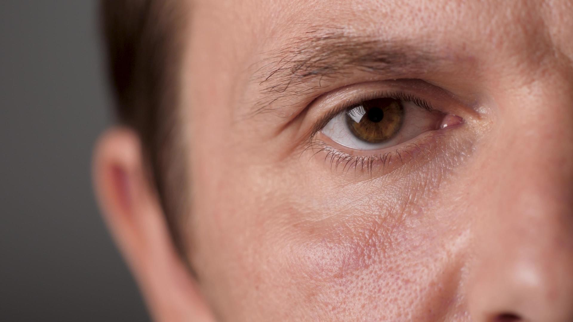 男人的棕色眼睛盯着镜头男人的眼睛不眨眼专注于凝视视频的预览图