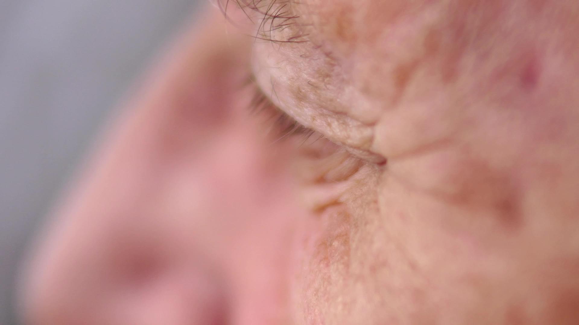 一张悲伤的蓝眼睛皱纹女人脸的近距离照片视频的预览图