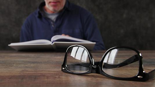 男人正在阅读眼镜脱焦概念视频的预览图
