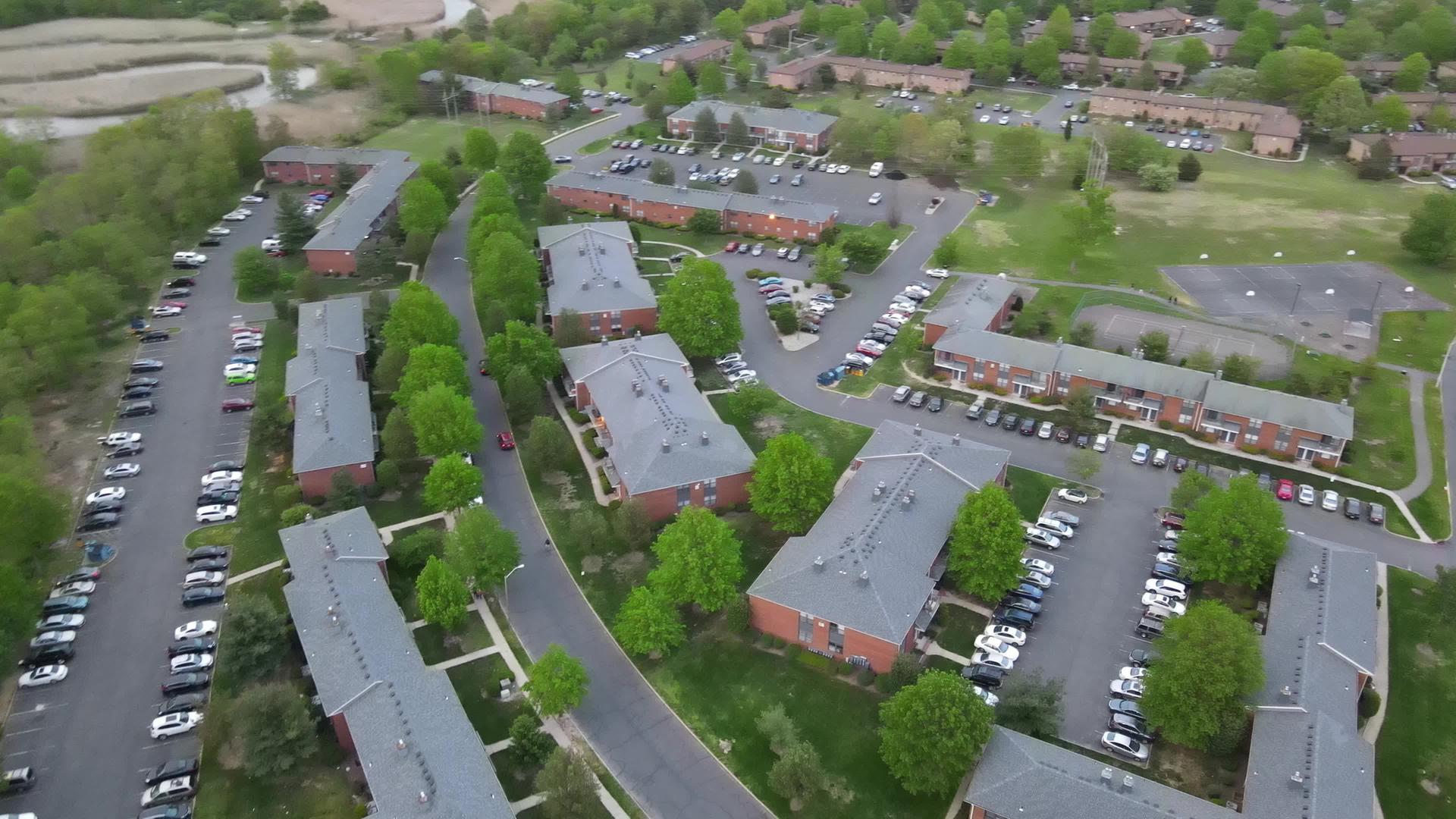 在鸟瞰住宅区的公寓楼和道路上汽车停在沥青上视频的预览图