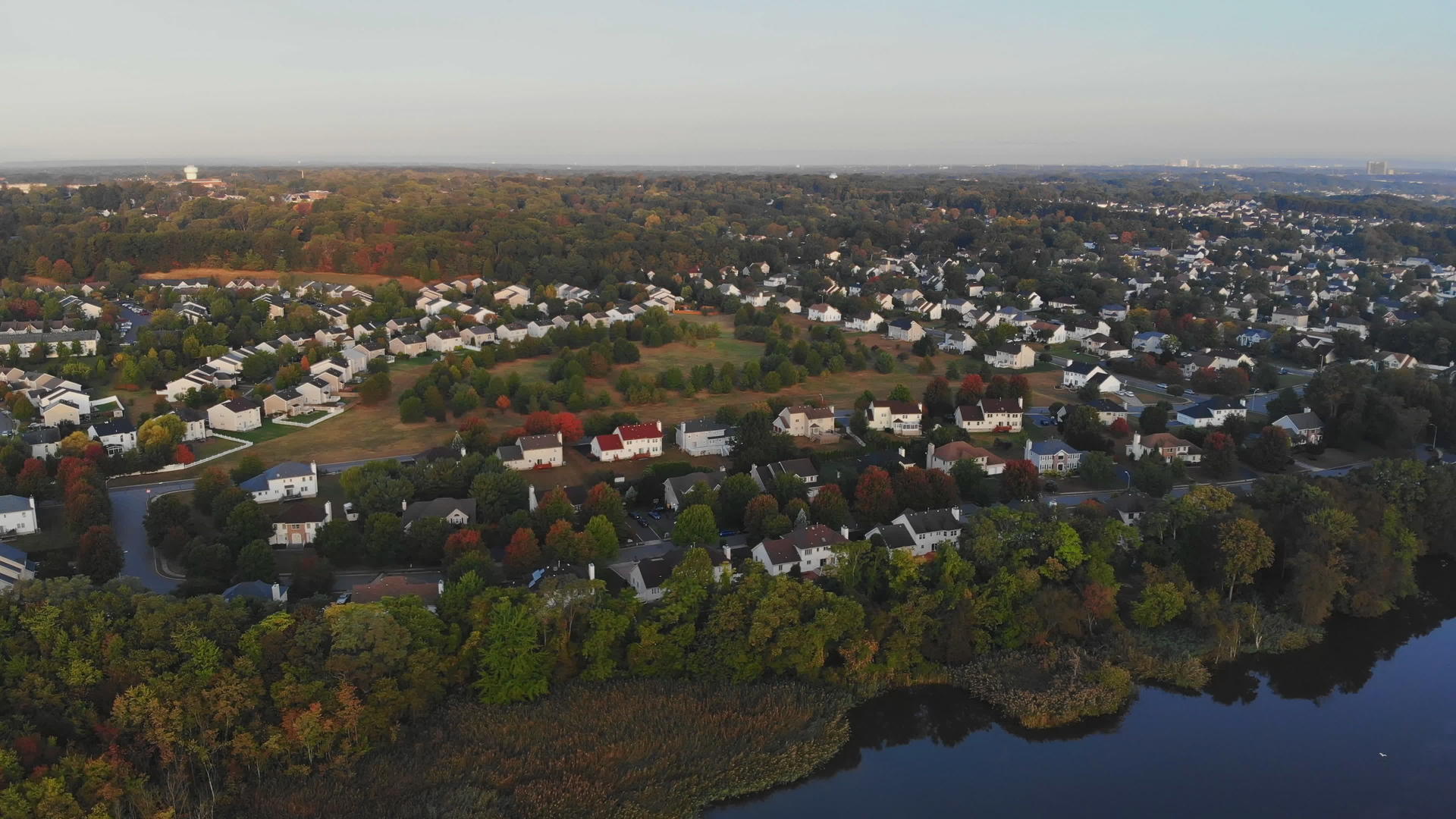 在秋天的风景中沿河地区的面积以长椅为基础可以看到住宅的屋顶视频的预览图