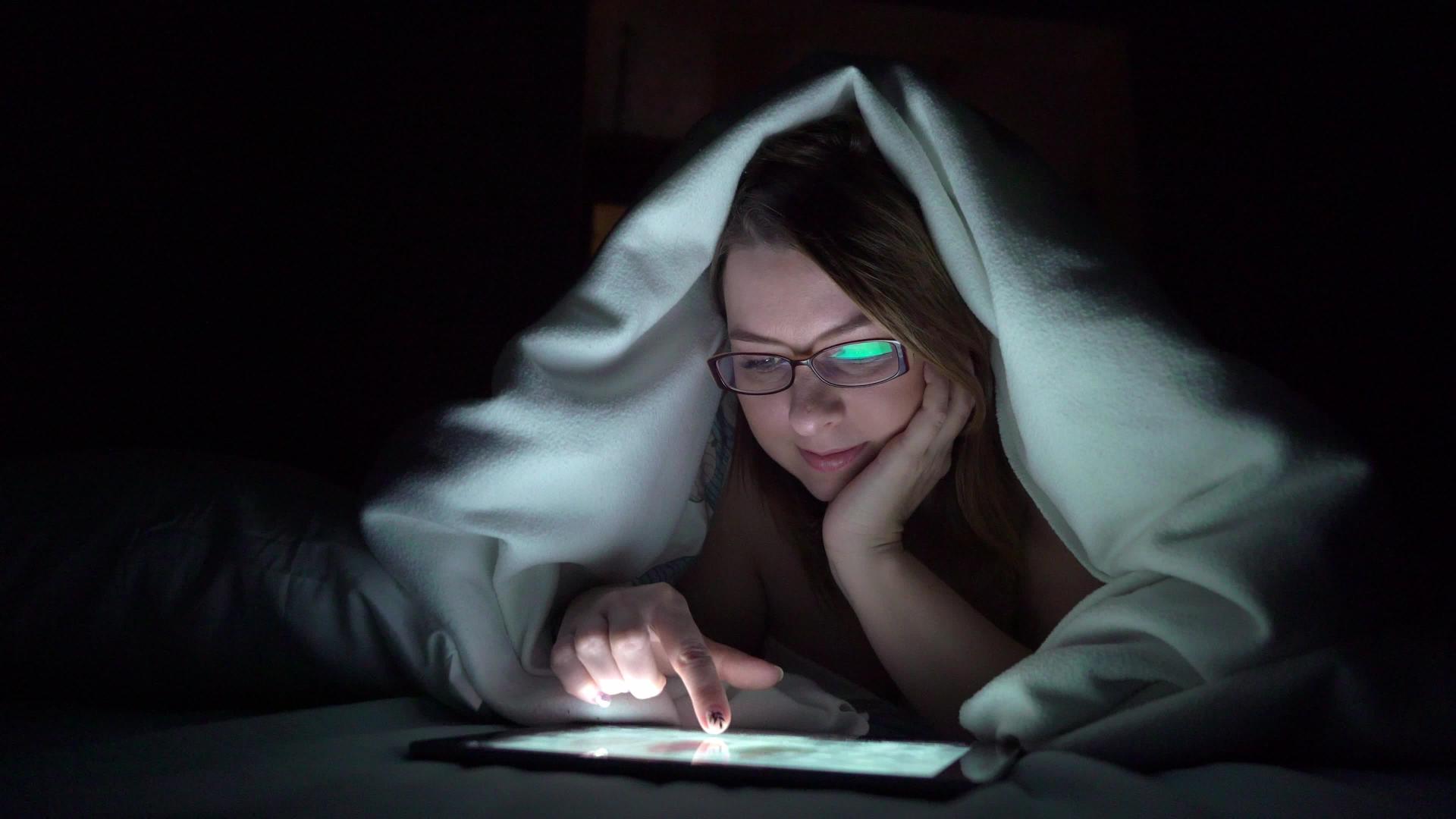 年轻女性在睡觉前在床上使用平板药物即手机成瘾者的概念视频的预览图