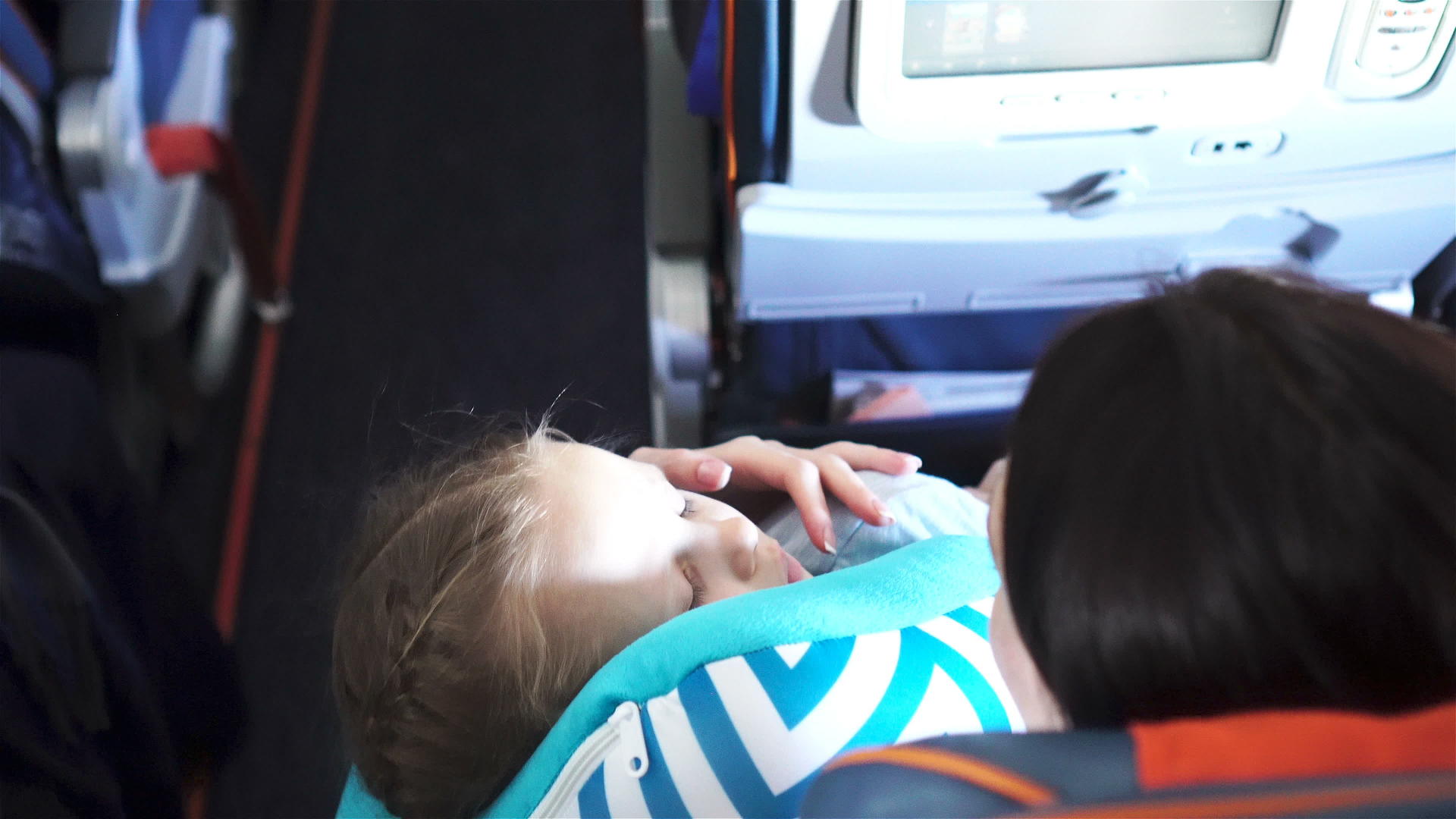 小女孩的母亲在航空旅行中睡在飞机上带着女儿坐飞机视频的预览图