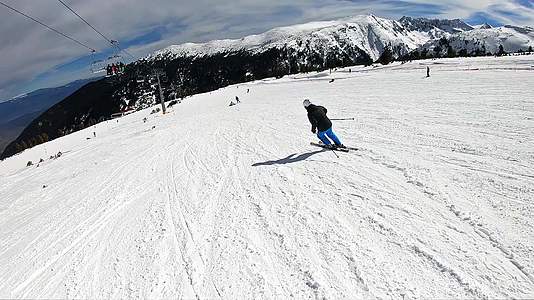 在晴朗的山峰上专业滑雪者从斜坡上滑下电影超级慢动作视频的预览图