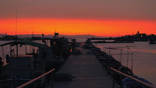 码头船和橙色天空的夜景视频的预览图