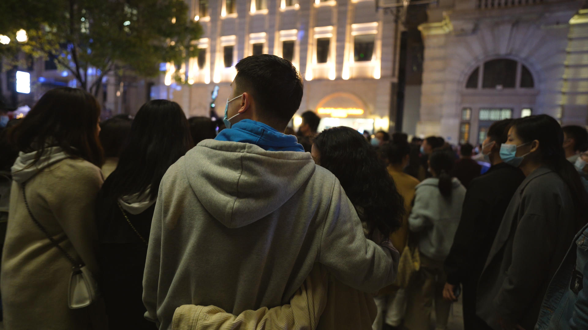 城市春天步行街夜晚相拥的情侣和拥挤的路人4k素材视频的预览图