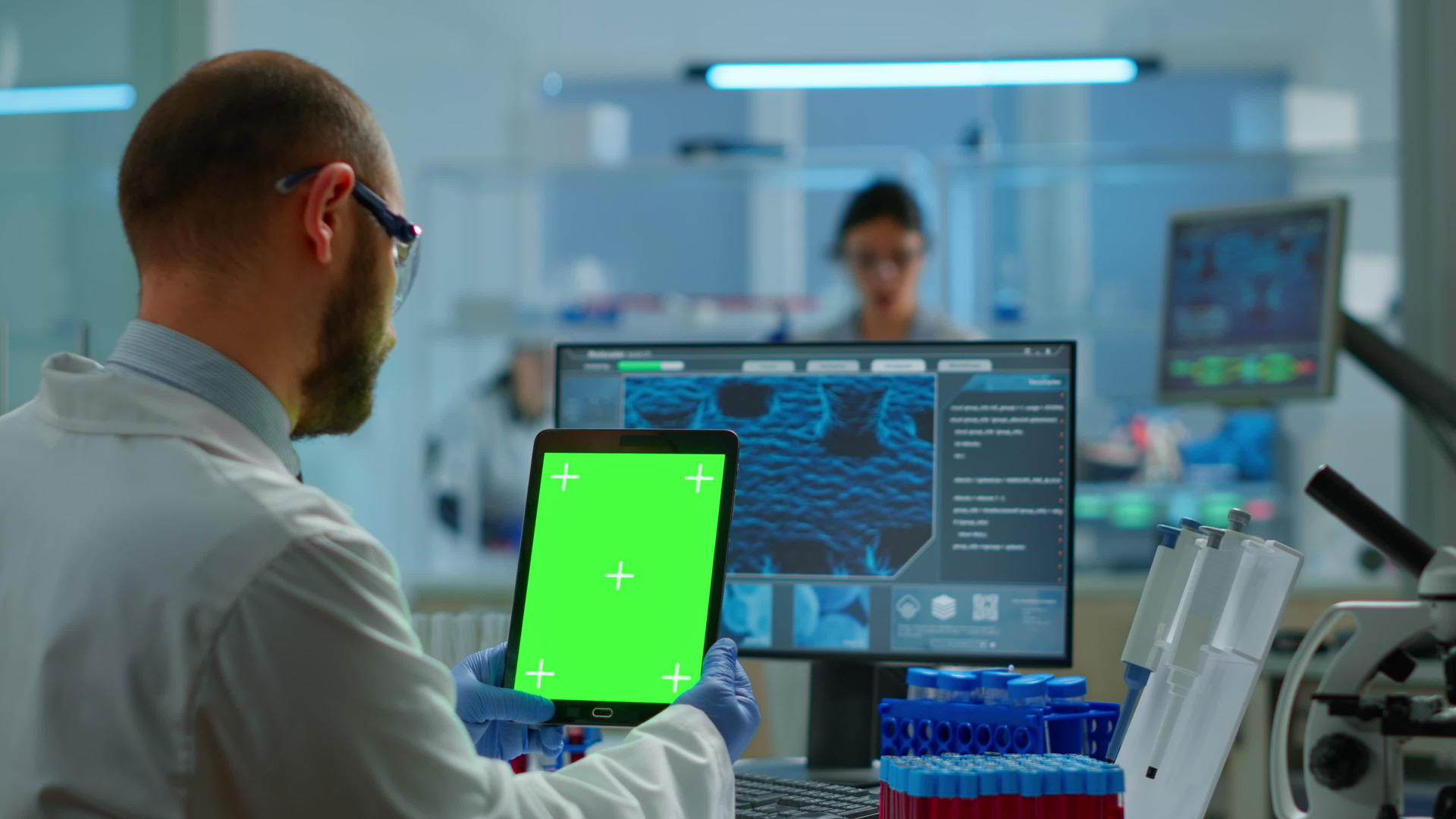 男医生在一个设备齐全的现代化实验室里拿着绿色的屏幕视频的预览图