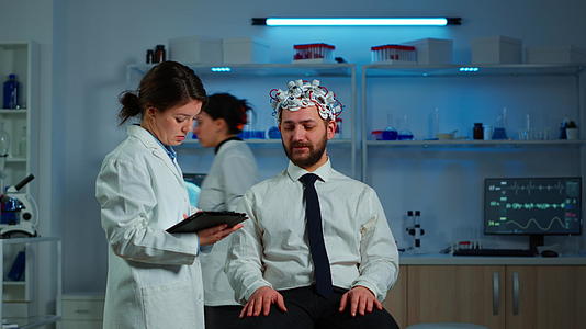 患者佩戴脑电波扫描耳机与神经研究人员讨论使用a视频的预览图