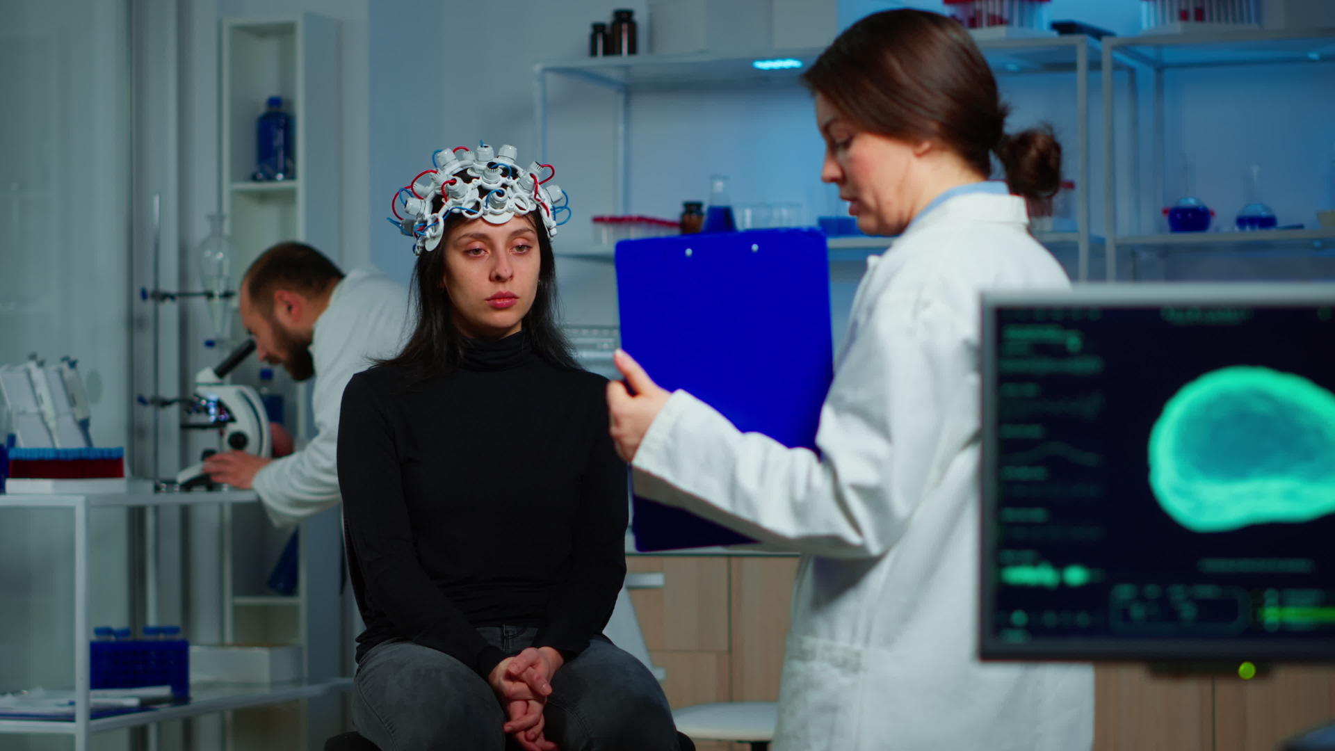 神经科学家医生持有剪贴板为患者提供治疗视频的预览图