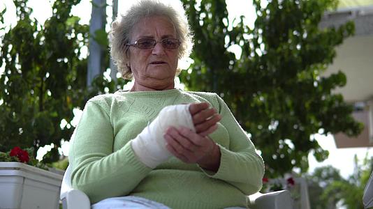 按摩受伤老妇人的手被打断坐在电影院Dof视频的预览图